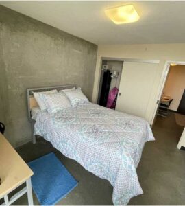 Photo of a Begin Tower residence suite with a bed, table and closet.